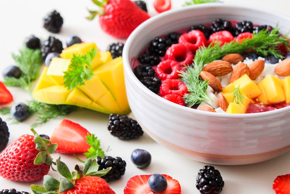 pexels-photo-1105166-1105166 A vibrant bowl filled with fresh berries, mango, almonds, and herbs, perfect for a healthy snack or breakfast.