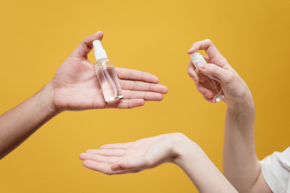 pexels-photo-3951862-3951862 Hands using hand sanitizer against a yellow background, highlighting hygiene.
