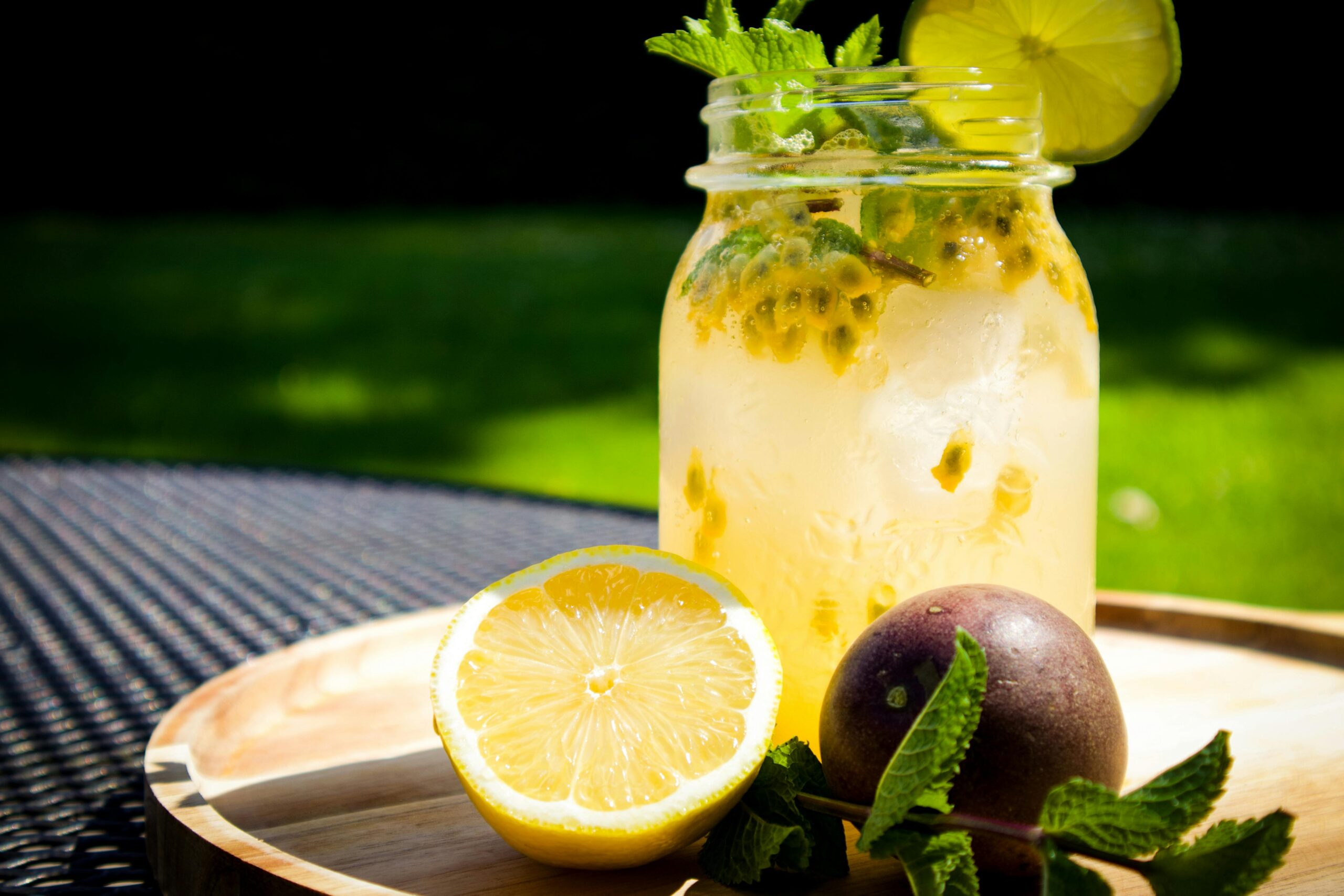 Chilled refreshment with citrus, mint, and passionfruit served outdoors for a healthy lifestyle.